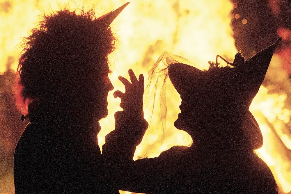 Siluett av to personer foran et bål, utkledd som heks og djevel: Blocksberg
