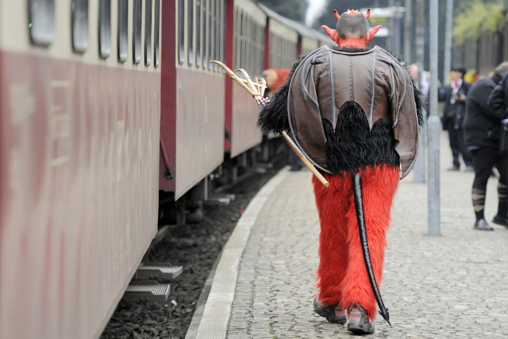 Mann i djevelkostyme på en togperrong: Blocksberg.
