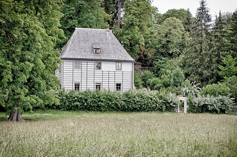 Hvitt hus med bratt tak i frodig hage. Johann Wolfgang von Goethe hus.