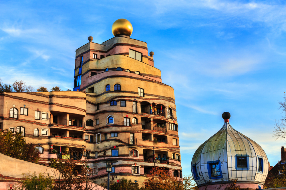 Fargerikt hus med runde former og gull-kuppel: Hundertwasser-huset i Darmstadt.